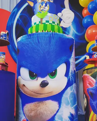 SONIC: painel com o Sonic do filme, vermelho e azul, bolo verde e azul. Festa realizada no Espaço Comemora em 2023