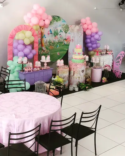 jardim encantado com borboletas de MDF, arco pastel arco-iris, gaiolas brancas. Festa realizada no Espaço Comemora em 2023