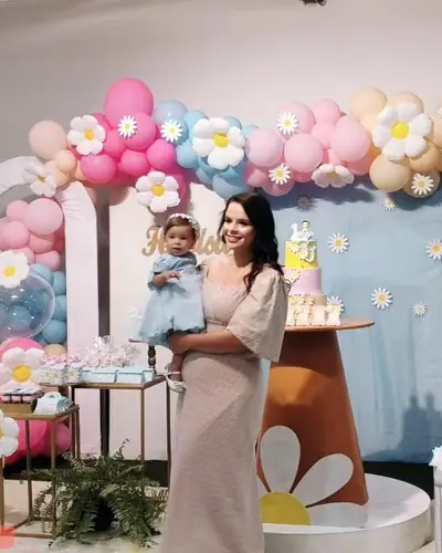 Heloisa, 1 ano; tema margaridas com baloes-flor, azul-serenity e rosa; 4 fotos. Festa realizada no Espaço Comemora em 2023