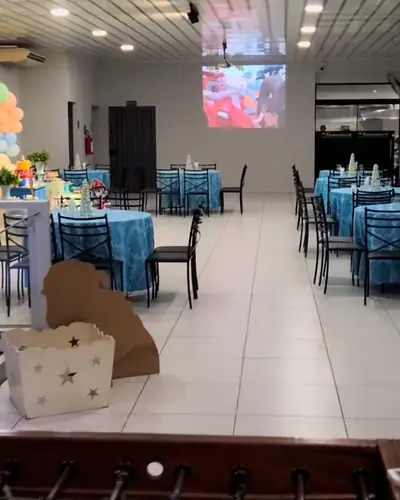 Patrulha Canina em pastel com neon 4; salao com PROJECAO e pebolim visiveis. Festa realizada no Espaço Comemora em 2024
