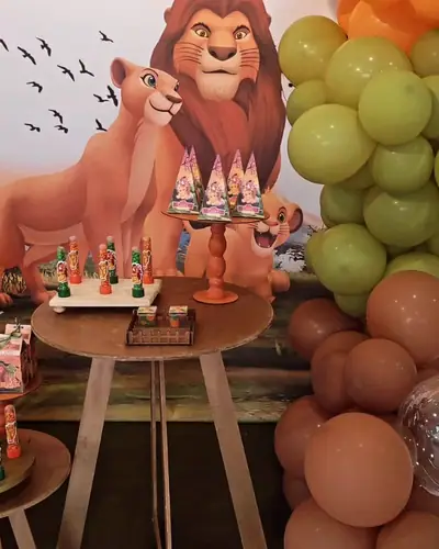 REI LEAO: painel com Simba e Nala, baloes verde-oliva e marrom, mesa de madeira. Festa realizada no Espaço Comemora em 2024