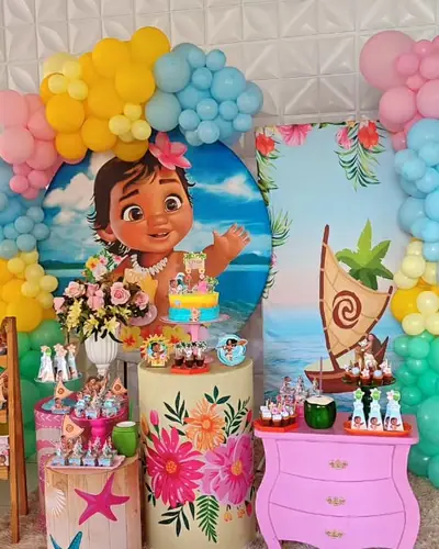 MOANA BABY: painel com a Moana crianca, flores tropicais, canoa, pastel arco-iris. Festa realizada no Espaço Comemora em 2024