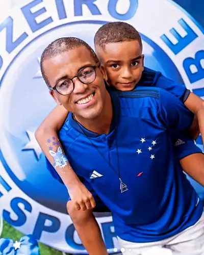 pai e filho com camisa do Cruzeiro diante do escudo. Festa realizada no Espaço Comemora em 2024