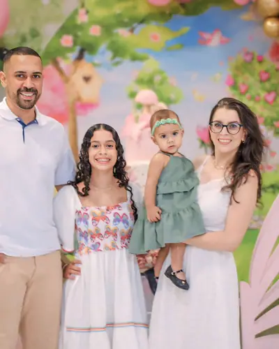 pai com a aniversariante; jardim em rosa, dourado e verde com borboletas de MDF. Festa realizada no Espaço Comemora em 2024