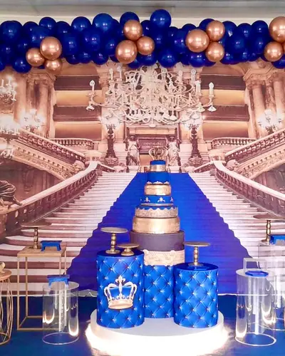 tema PRINCIPE: painel de escadaria de palacio, azul-marinho e dourado rose, coroa. Festa realizada no Espaço Comemora em 2024