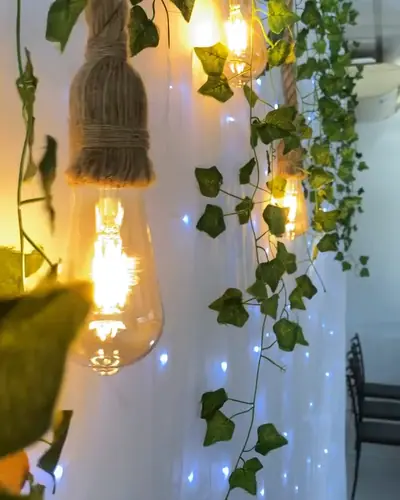 folhagens penduradas com lampadas filamento; estetica de casamento ou evento adulto. Festa realizada no Espaço Comemora em 2024