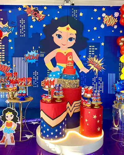 MULHER-MARAVILHA: painel de cidade em quadrinhos, vermelho, azul e dourado. Festa realizada no Espaço Comemora em 2024