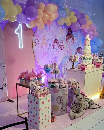 1 aninho da Rebeca; bonecas de pano, pastel lilas e pessego, tigre e leao de pelucia. Festa realizada no Espaço Comemora em 2024