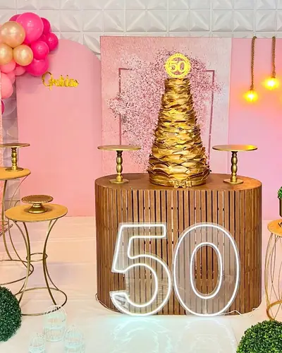 FESTA ADULTA de 50 anos: rosa e dourado, mesas altas, numero 50 iluminado. Festa realizada no Espaço Comemora em 2024