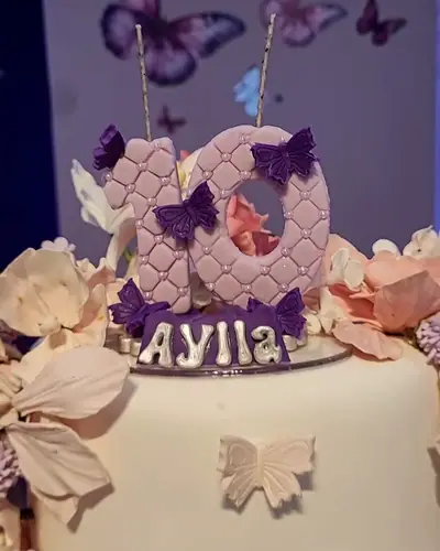 bolo branco com borboletas lilas e o nome AYLLA aplicado. Festa realizada no Espaço Comemora em 2025