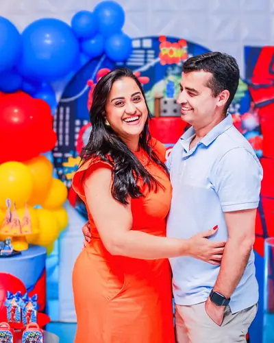 casal diante de painel do Homem-Aranha com predios. Festa realizada no Espaço Comemora em 2025