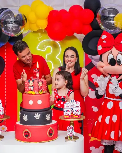 Mickey e Minnie fantasiados presentes; bolo 3 andares, neon 3. Festa realizada no Espaço Comemora em 2025